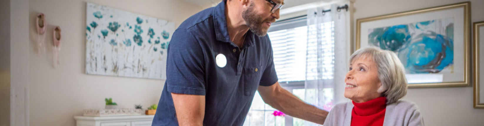 caregiver helping woman out of bed