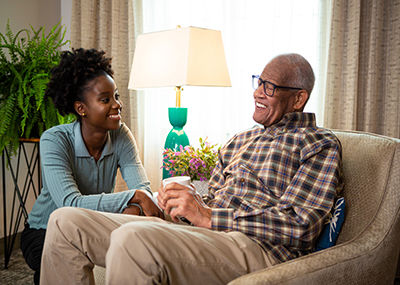 woman kneeling next to a man sitting in a chair