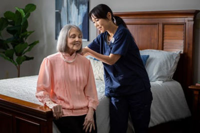 caregiver helping resident put on necklace
