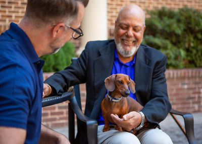 Man with wiener dog and associate