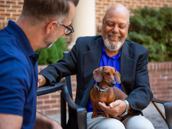 Man with wiener dog and associate