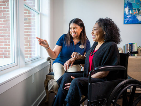 Associate and woman looking out the window