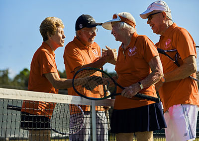 four seniors playing tennis