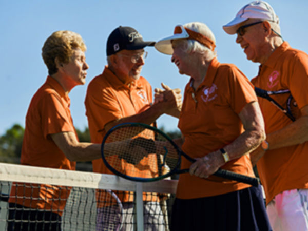 four seniors playing tennis